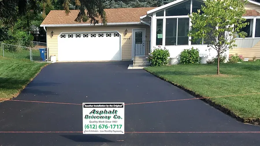 Finished asphalt driveway with the company yard sign