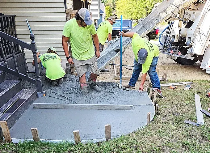 Crew finishing a new concrete patio